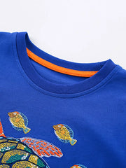 Blue cotton blend toddler t-shirt with embroidered turtle and fish graphic, crew neck.