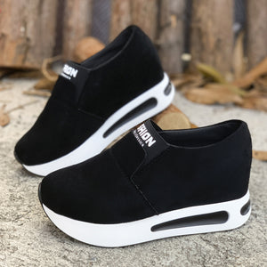 Black round toe platform slip-on sneakers with white soles and air cushioning.
