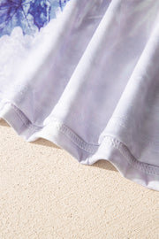 Tunic tee with faded blue and white abstract print, crew neck, and visible stitching detail.