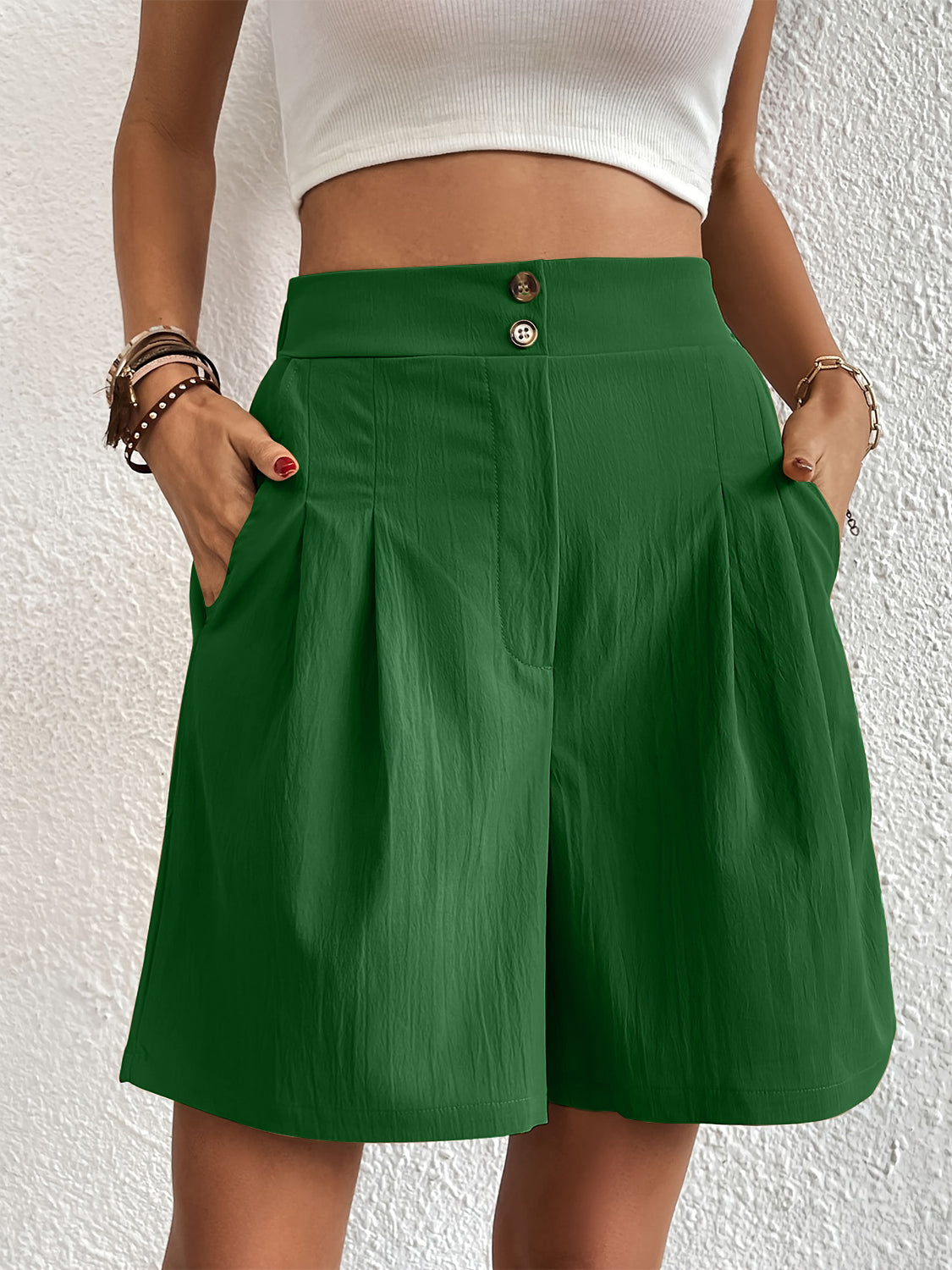 Pleated front bermuda shorts in dark green with button closure and side pockets.