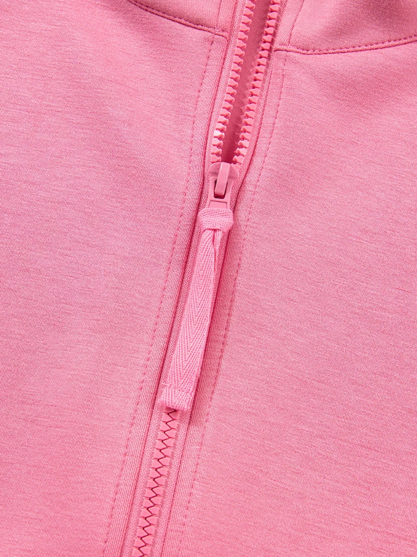 Dusty pink zip-up hoodie detail with textured zipper pull and fabric.