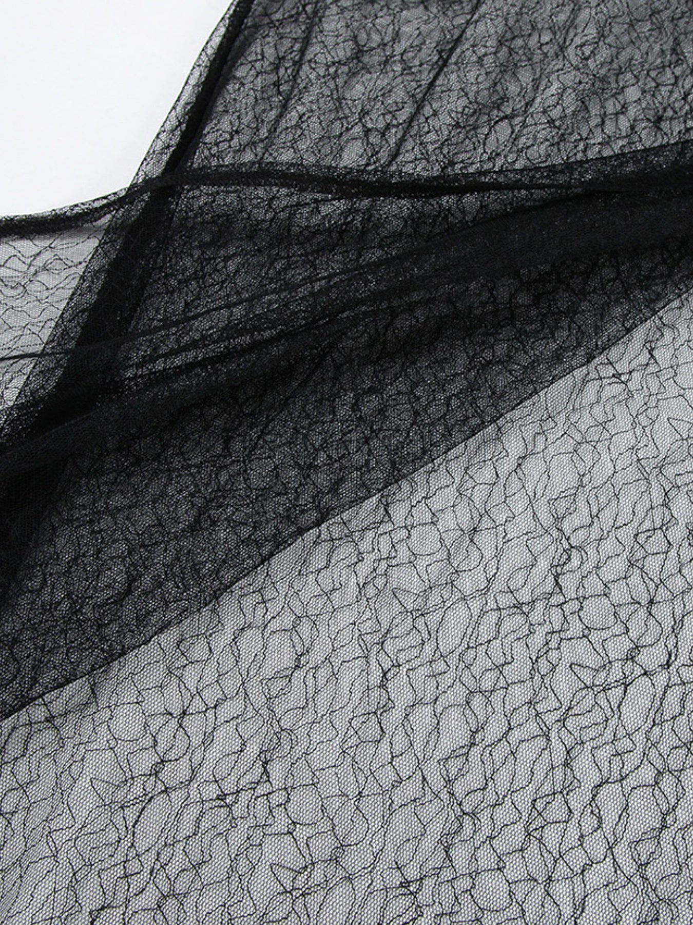 Black lace midi skirt with sheer panel detail and asymmetrical hem.