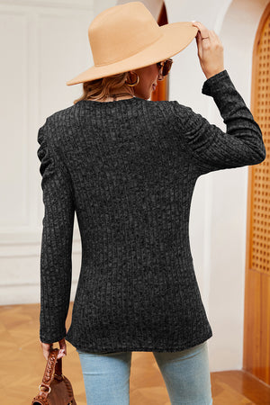 Textured black blouse with ruched sleeves and a crew neck, styled casually.