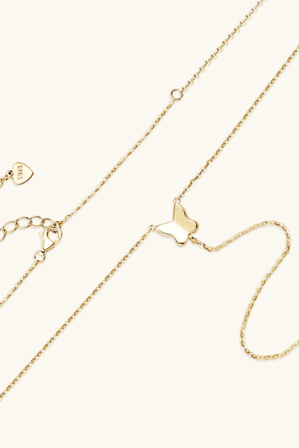 Gold lariat necklace with a butterfly pendant and adjustable clasp.