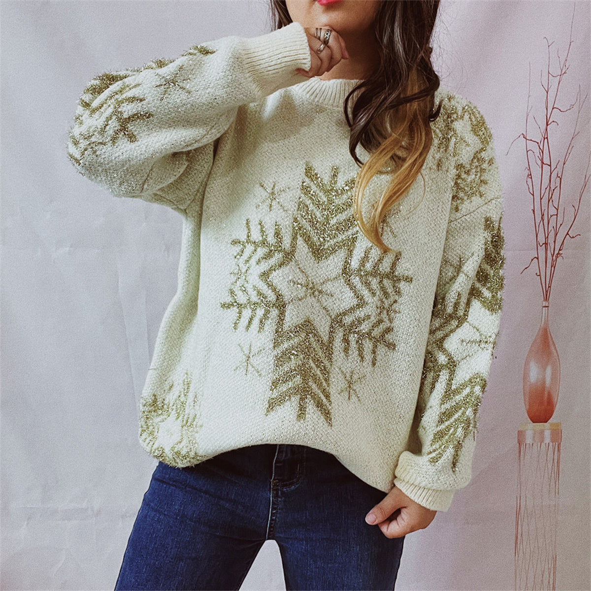 Cream knit sweater with gold snowflake embellishments and crewneck.