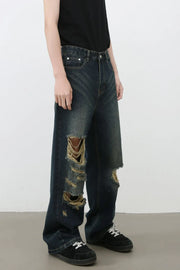 Distressed wide-leg dark wash denim jeans with prominent knee tears and a relaxed fit.