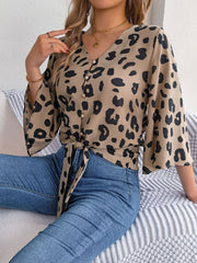 Khaki leopard print tie-front blouse with button detail and bell sleeves.