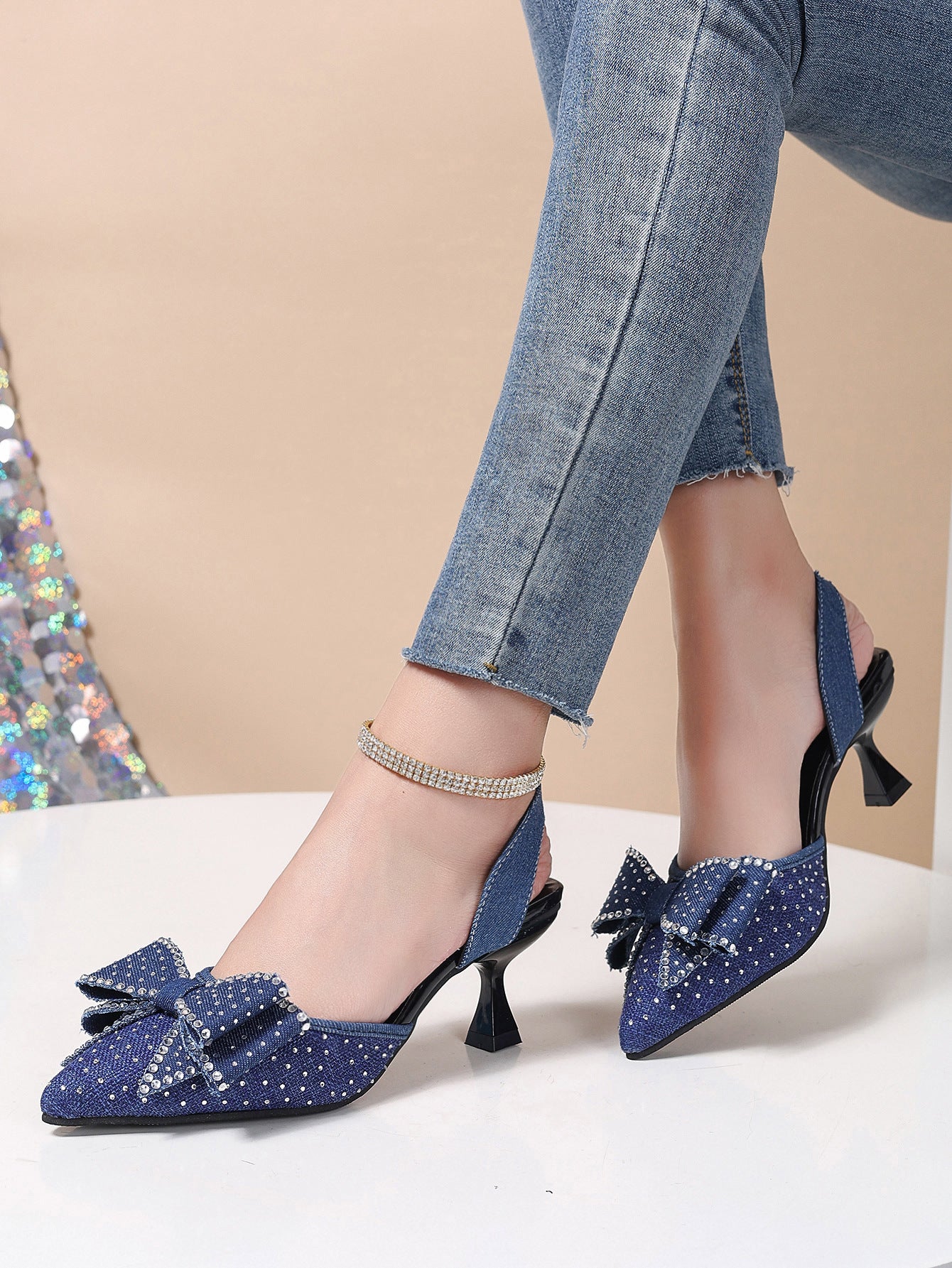 Blue denim slingback heels with rhinestone bowknot detail and ankle strap.