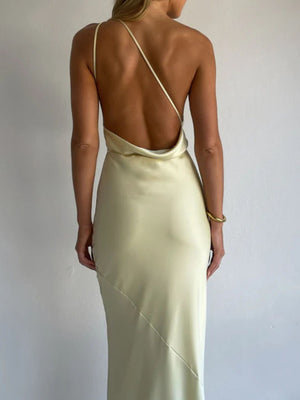 Yellow satin halter maxi dress with asymmetric neckline and open back.