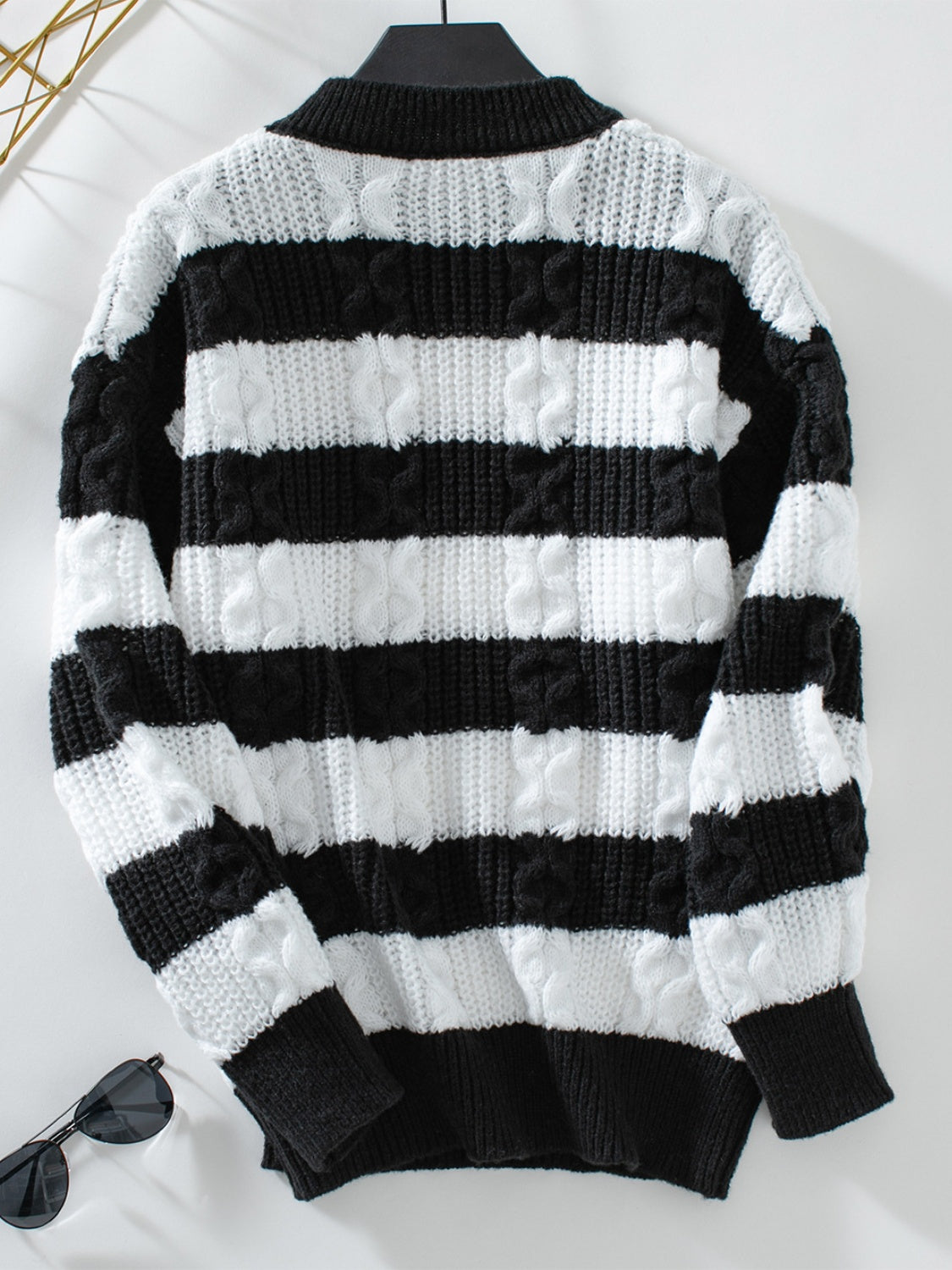 Black and white striped cable knit crewneck sweater with a mock neck.