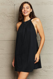 Black halter mini dress with gathered neckline and open back detail.
