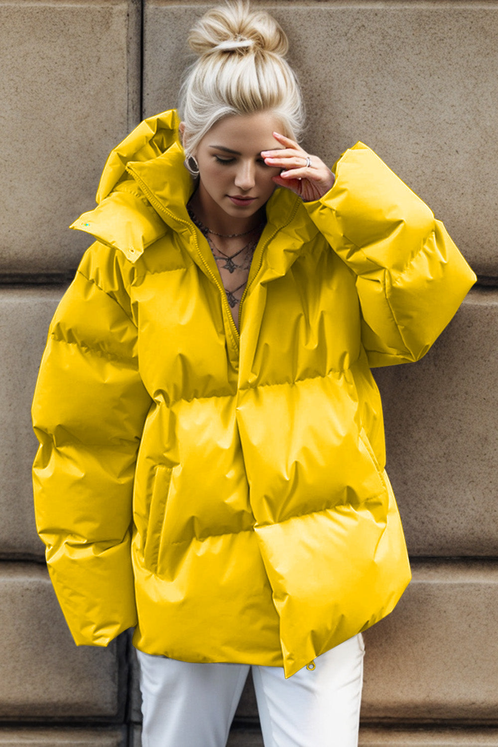 Yellow oversized puffer jacket with hood and zipper closure, casual style.