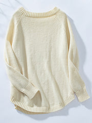 Cream acrylic cable knit sweater with button shoulder detail and raglan sleeves.