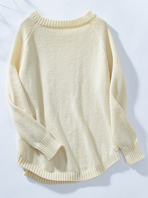 Cream acrylic cable knit sweater with button shoulder detail and raglan sleeves.