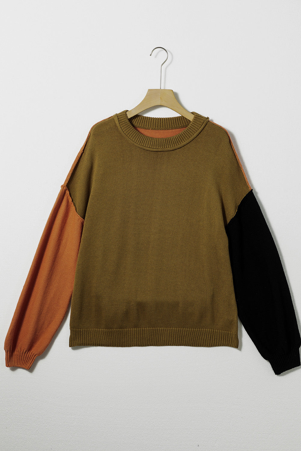 Sweater with contrast sleeves in olive, black, and rust orange.