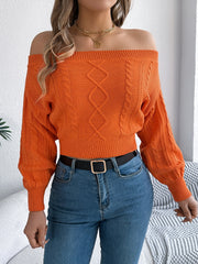 Orange cable knit off-shoulder crop sweater with diamond and cable knit details.
