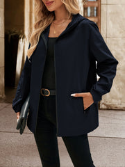 Navy zip-through hooded jacket with pockets, styled casually.