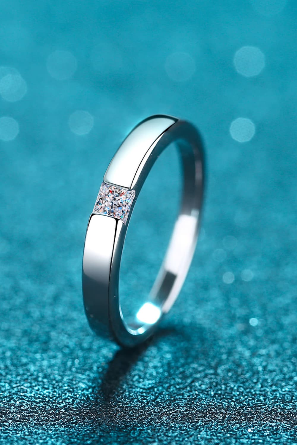 Silver band ring with a square-cut solitaire diamond accent.