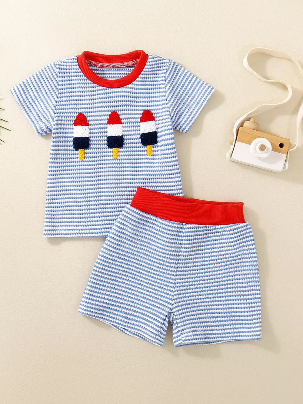 Baby tee and shorts set in Ice Cream blue stripes with rocket embroidery and red trim.