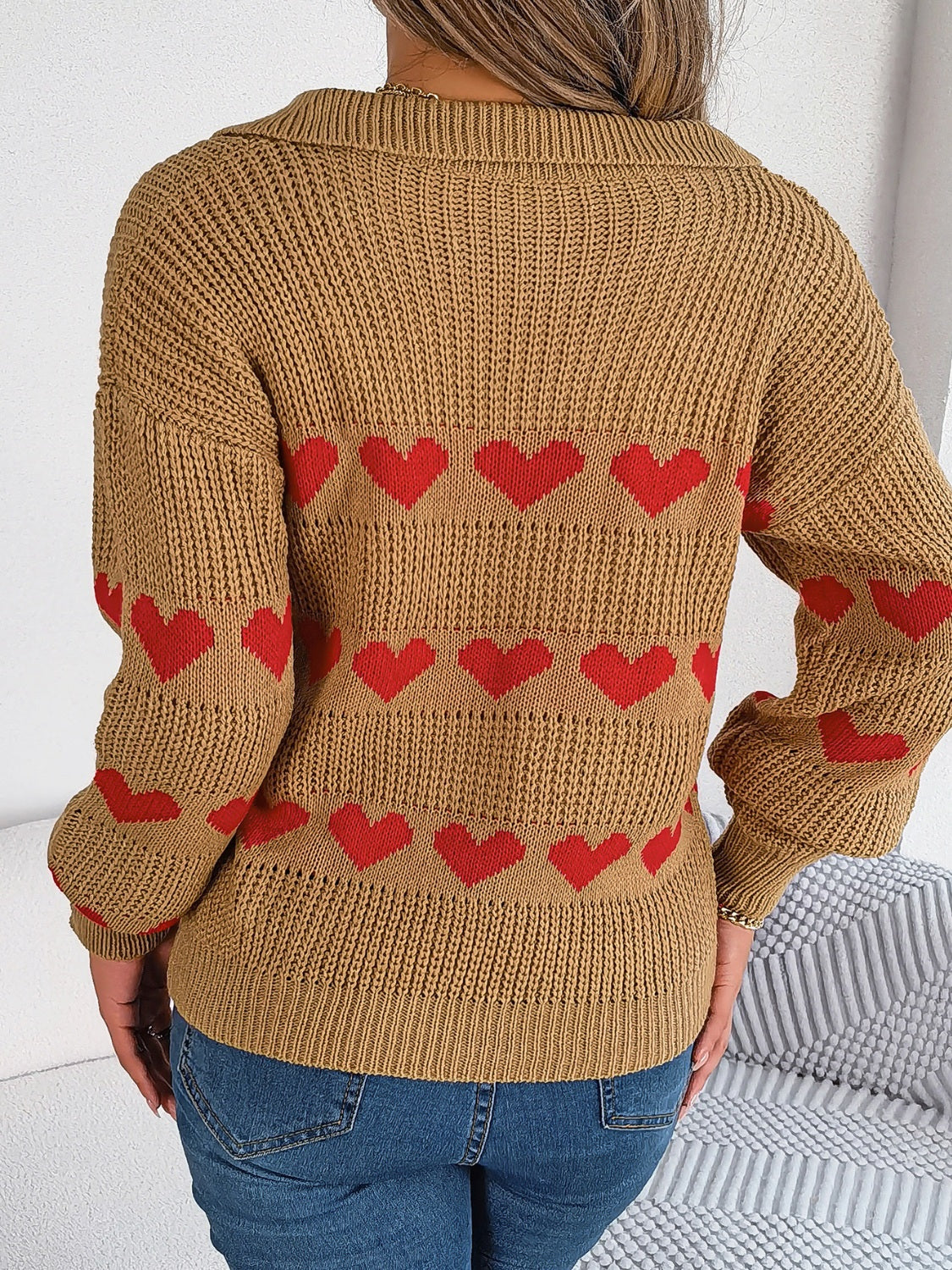 Camel knit polo sweater with red heart stripe pattern and collared neckline.