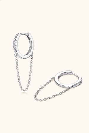 Silver dangling chain pavé huggie earrings with cubic zirconia accents.