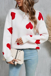 White acrylic knit jumper with red intarsia hearts, crew neck, long sleeves.