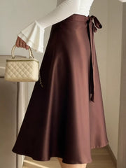 Tied-waist satin midi skirt in burgundy with a bow detail.