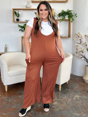 Brown wide-leg pocket jumpsuit with deep V-neck and sleeveless design.