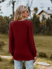 Burgundy V-neck blouse with Swiss dot puff sleeves and a relaxed fit.