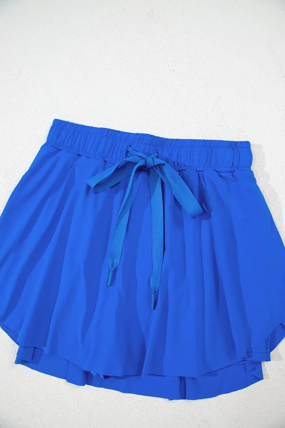 Blue flared skort with elastic waist and tie detail