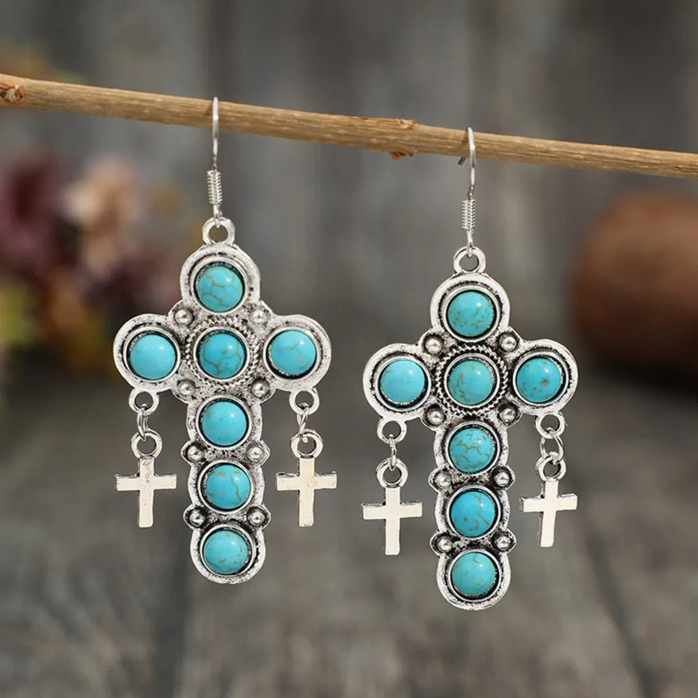 Southwestern turquoise cross dangle earrings with small cross charms.