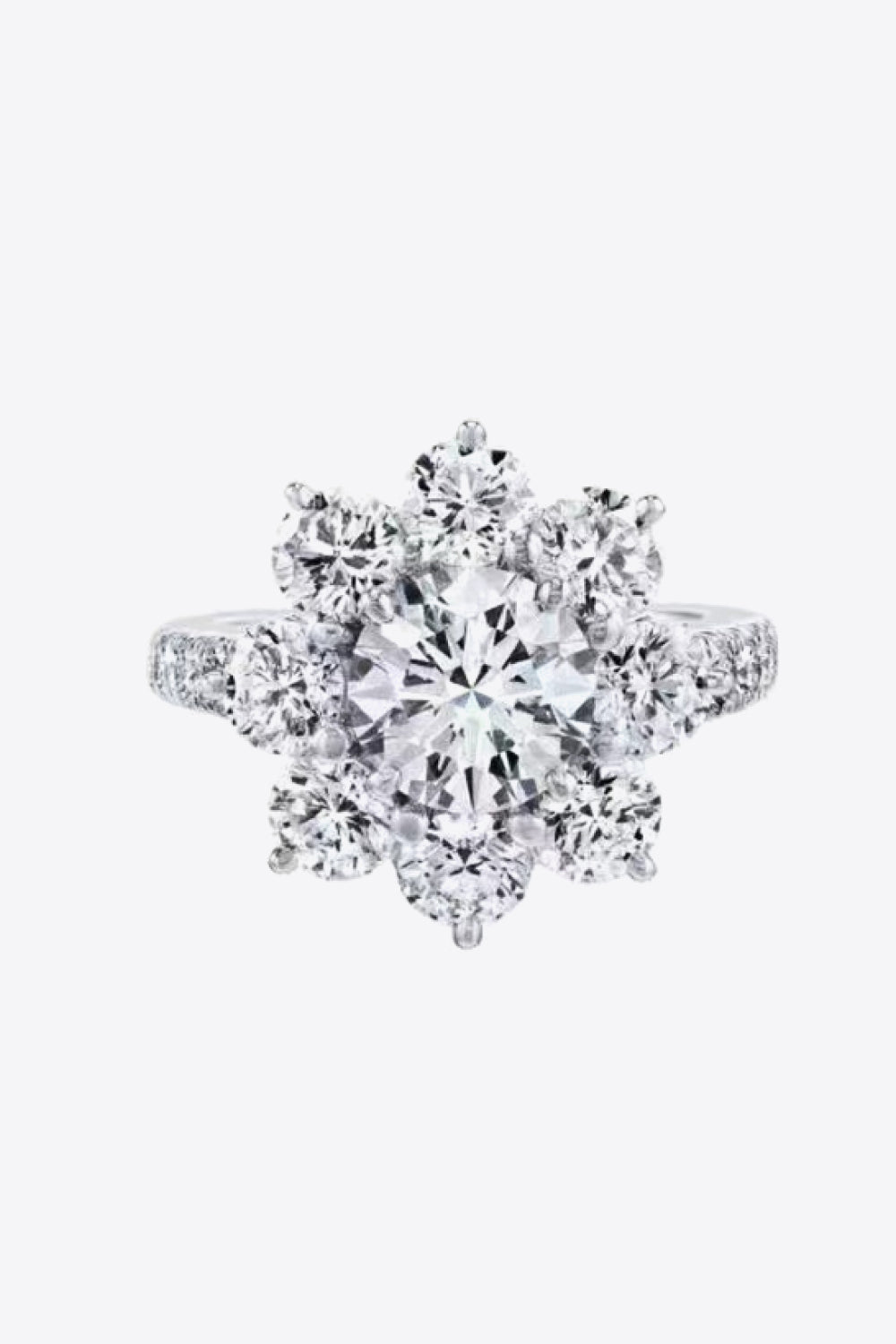 Silver moissanite engagement ring with a central round cut stone surrounded by a petal cluster of smaller stones.