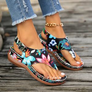 Embroidered floral thong wedge sandals with adjustable ankle strap and buckle.