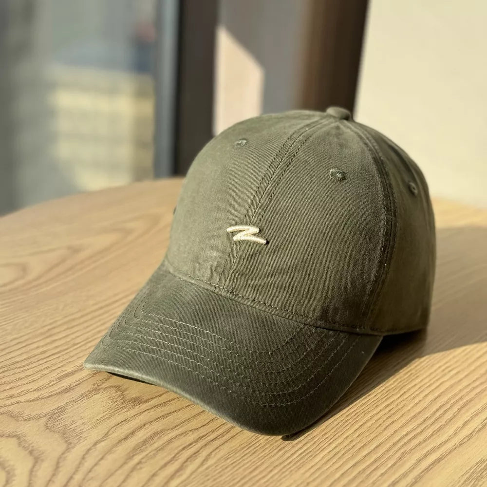 Distressed olive green cotton baseball hat with curved brim and embroidered detail.