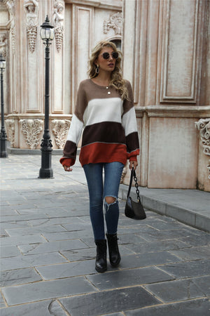 Crewneck knit sweater with color blocking in brown, white, dark gray, and rust.