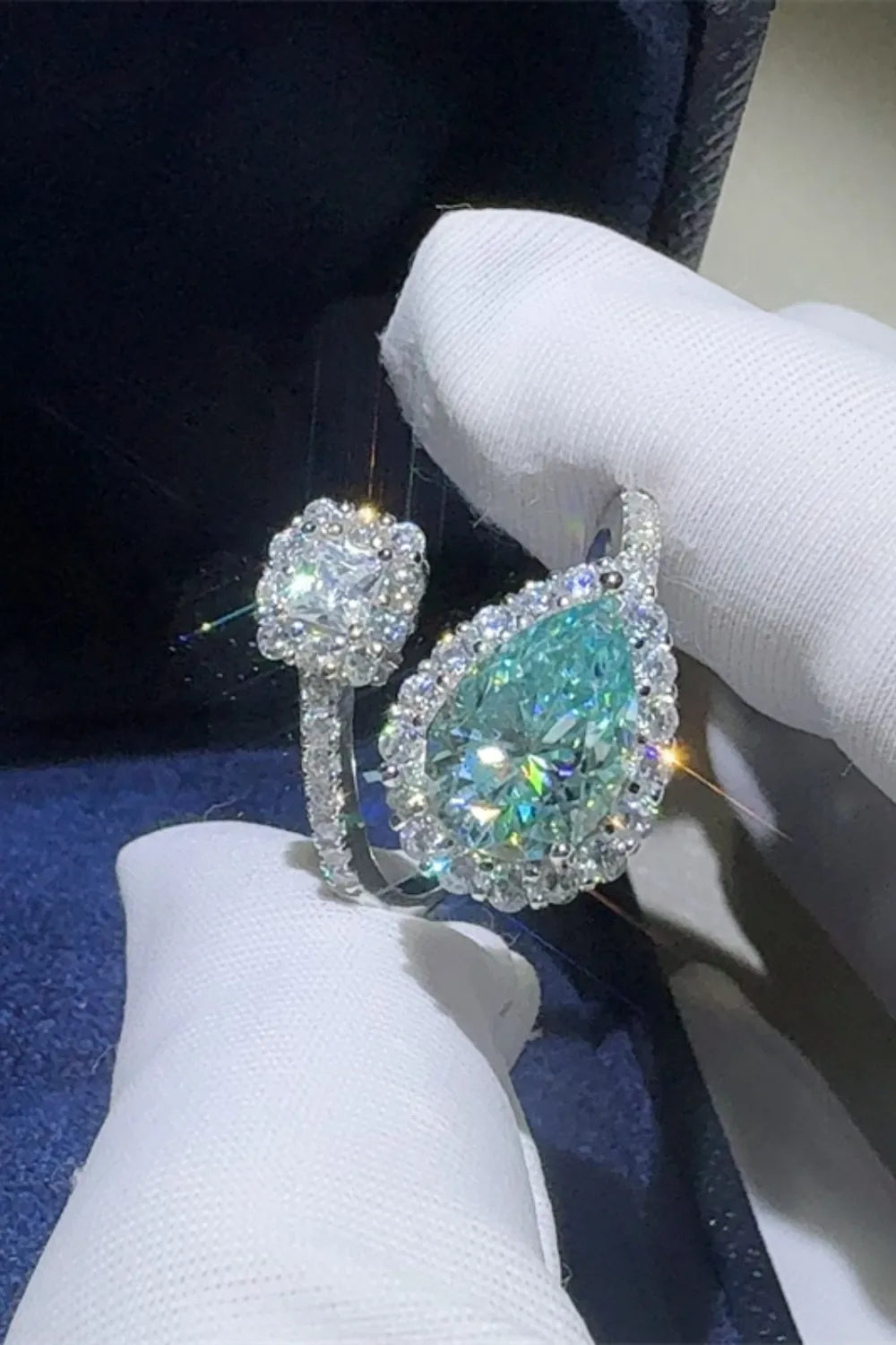 Bypass ring with turquoise pear-cut moissanite and diamond halo.