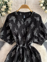 Black printed drawstring jumpsuit with short sleeves and v-neck.