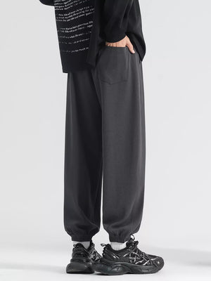 Men's dark gray loose fit sweatpants with drawstring and cuffed ankles.
