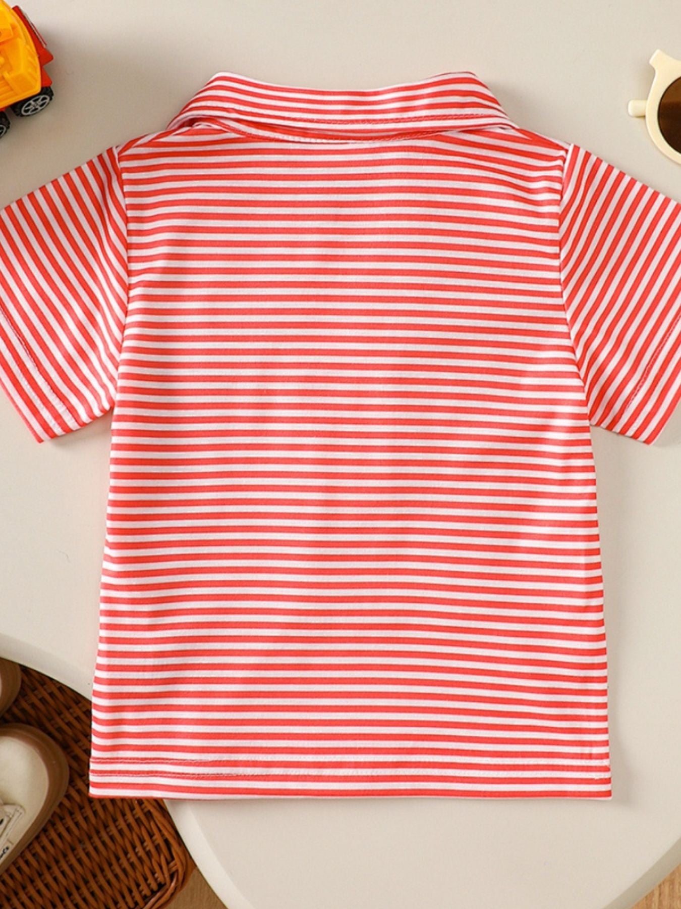 Coral and white striped baby polo shirt with a classic collar and short sleeves.