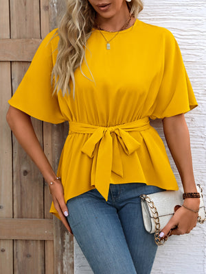 Yellow tie-waist blouse with short dolman sleeves and asymmetrical hemline.