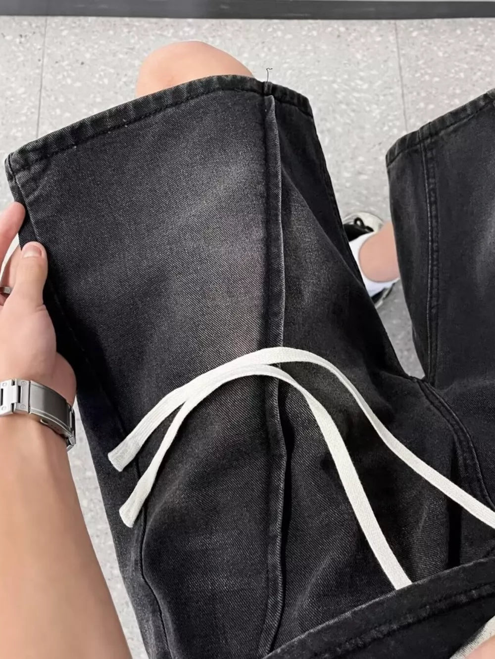 Black denim shorts with drawstring waist and contrast stitching.