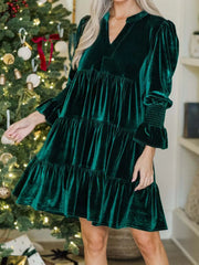 Dark green velvet tiered mini dress with smocked cuffs and notched neckline.