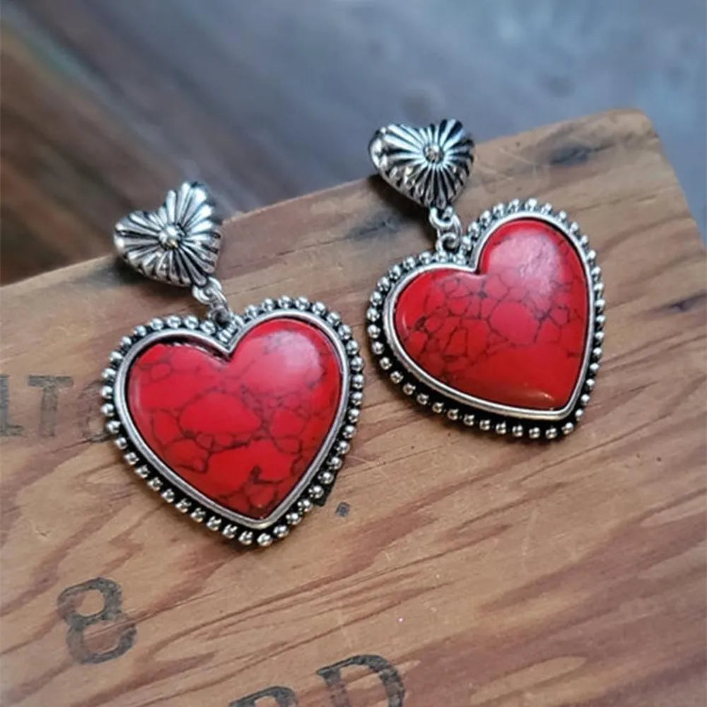 Deep red heart stone drop earrings with silver beaded trim and sunburst tops.