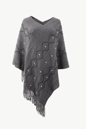 Charcoal geometric knit poncho with pearl embellishments and fringe detail.