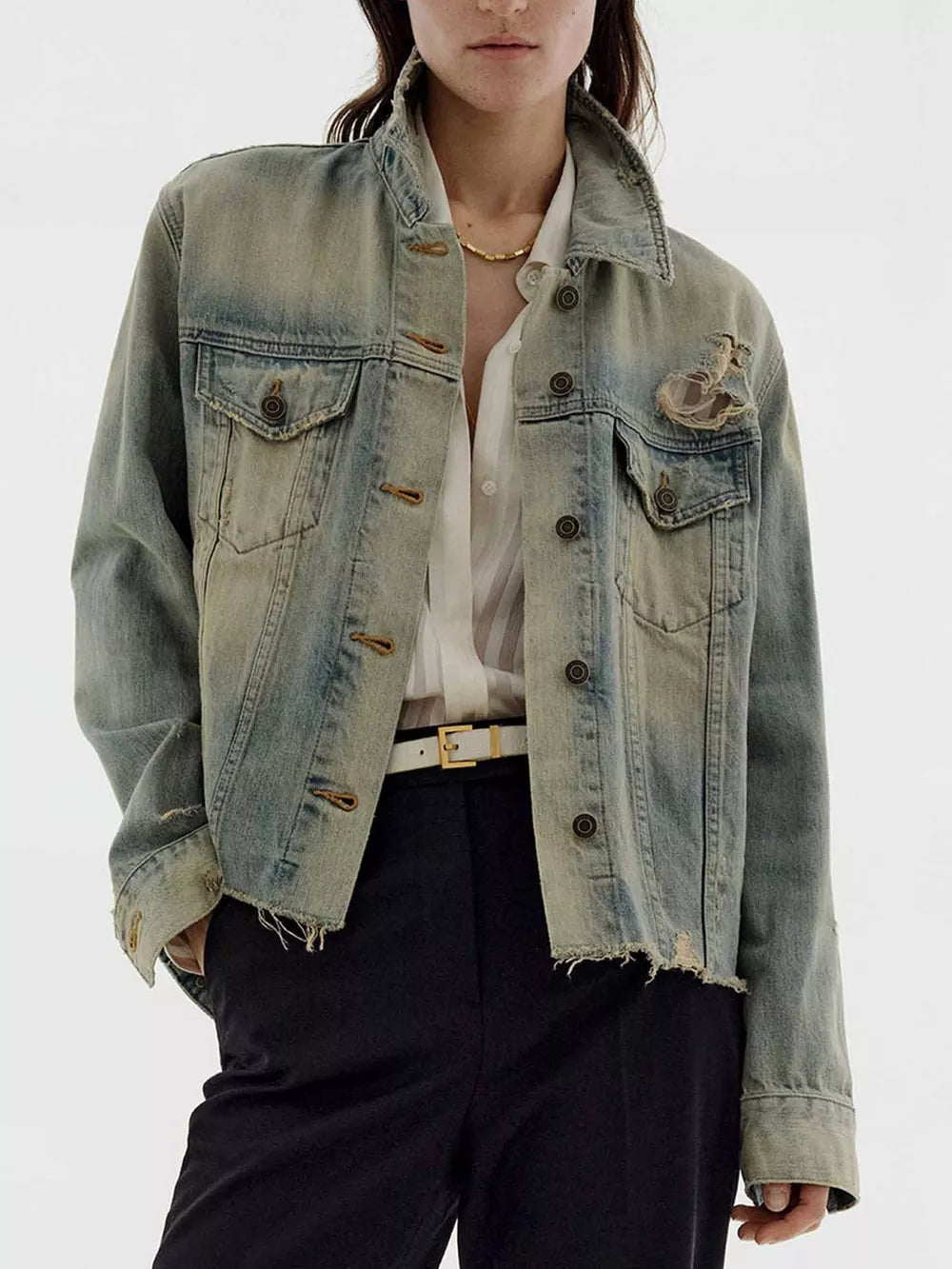Distressed light wash denim trucker jacket with button-up front and frayed hem.
