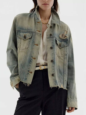 Distressed light wash denim trucker jacket with button-up front and frayed hem.