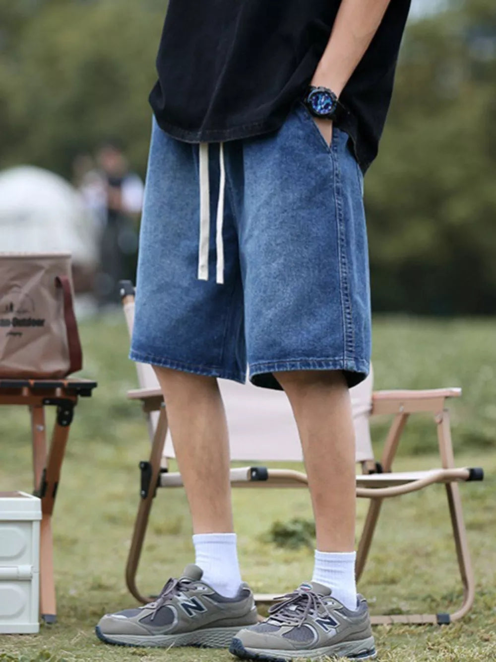Relaxed fit blue denim shorts with white drawstring and pockets.