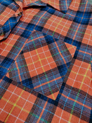 Orange plaid shacket with relaxed fit and chest pocket.