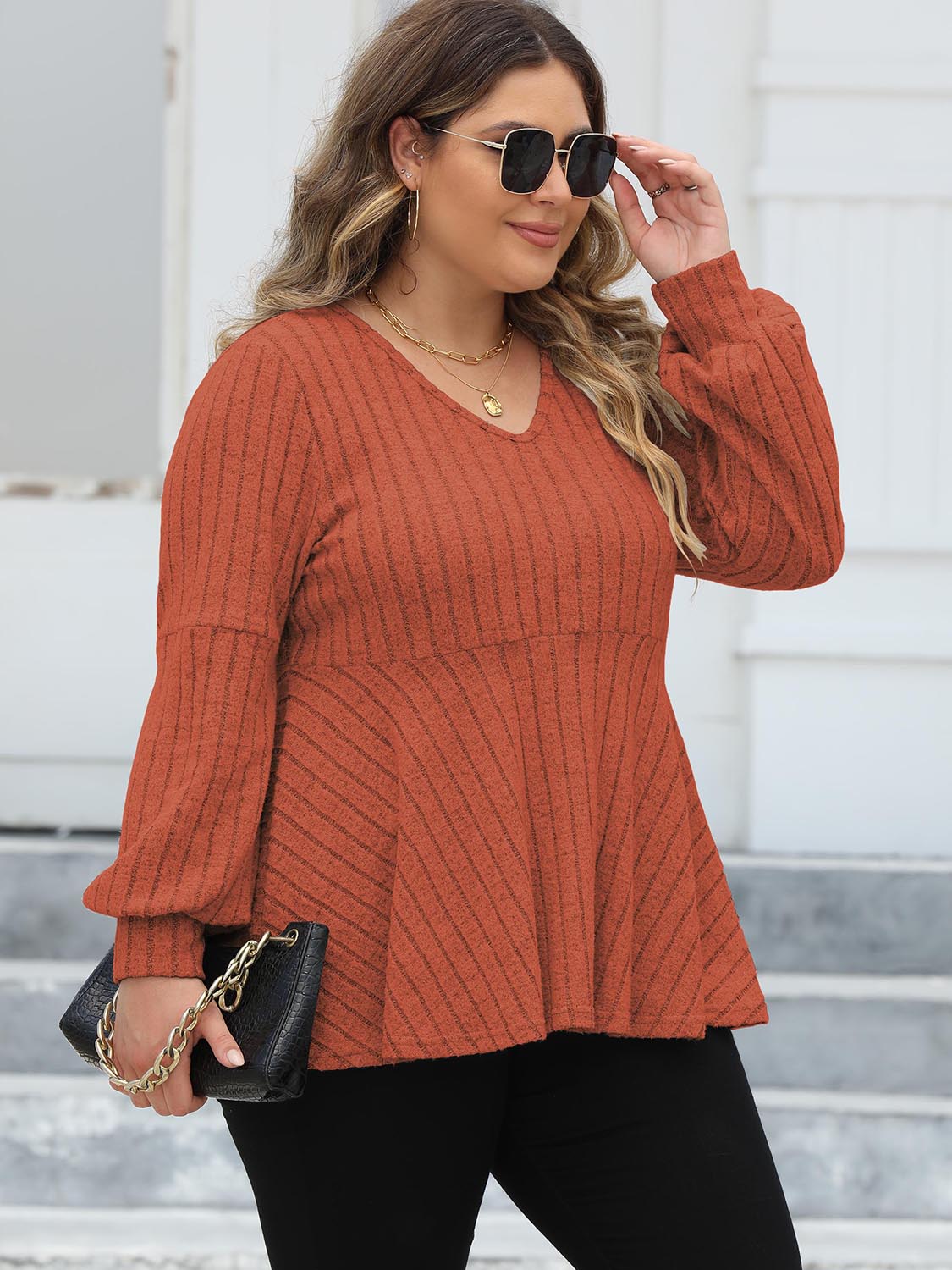 Ribbed peplum blouse in Red Orange with blouson sleeves and V-neck.
