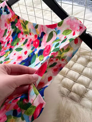 Vibrant floral midi dress with a pleated skirt in pink and yellow with a watercolor floral print.